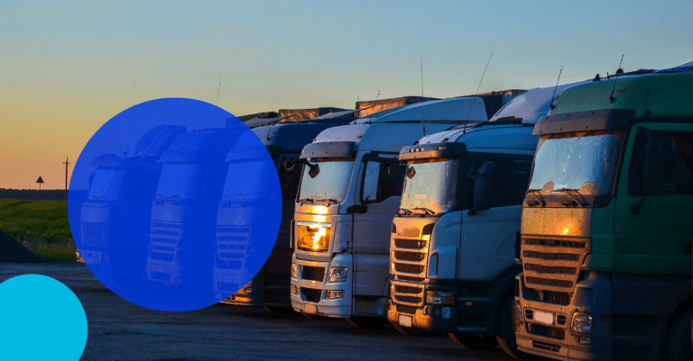 Australian commercial trucks lined up at sunset with a TreviPay droplet overlayed with white text saying "Heavy Commercial Industry in Australia: Compare and Contrast with the U.S. and Europe"