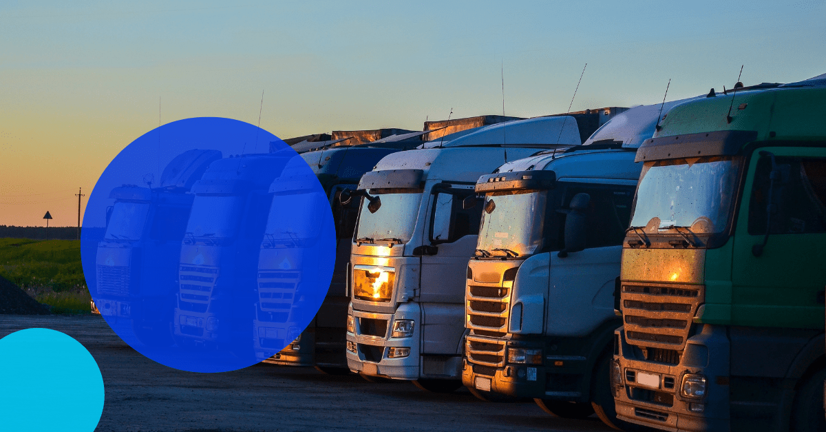Australian commercial trucks lined up at sunset with a TreviPay droplet overlayed with white text saying "Heavy Commercial Industry in Australia: Compare and Contrast with the U.S. and Europe"