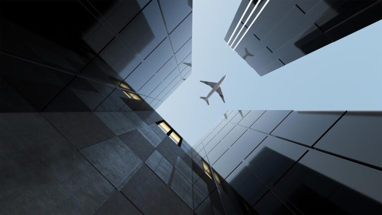 ground level view of an airplane flying over buildings