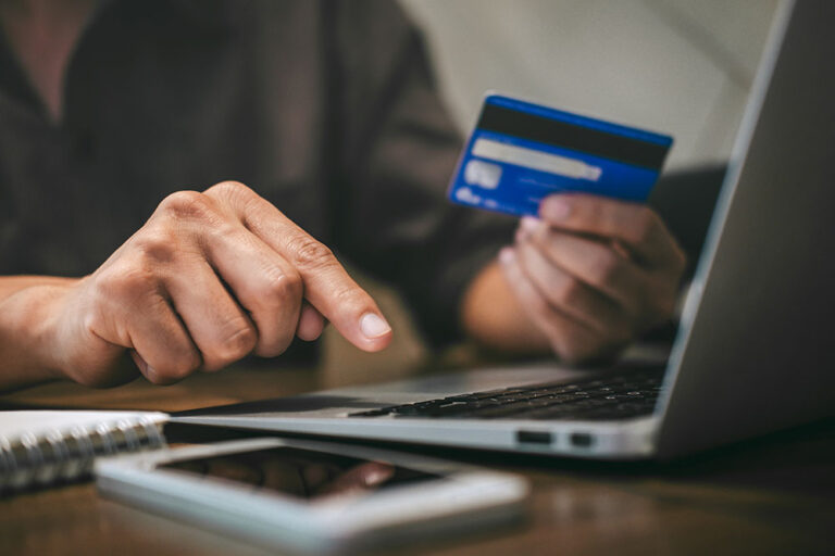 person making payment on laptop with credit card