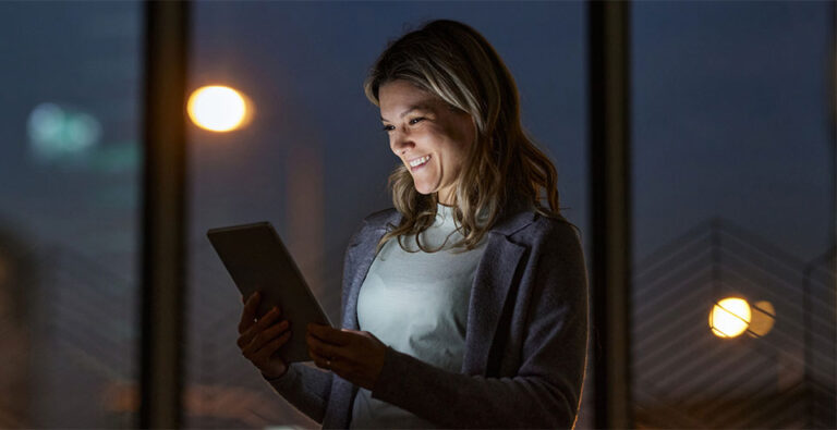 smiling women on tablet at night