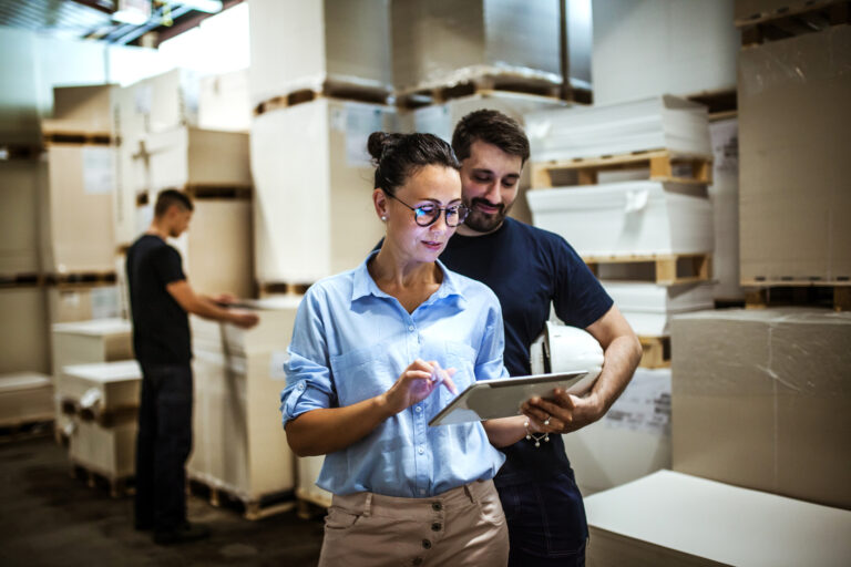 Warehouse supervisor walking and talking with senior manager